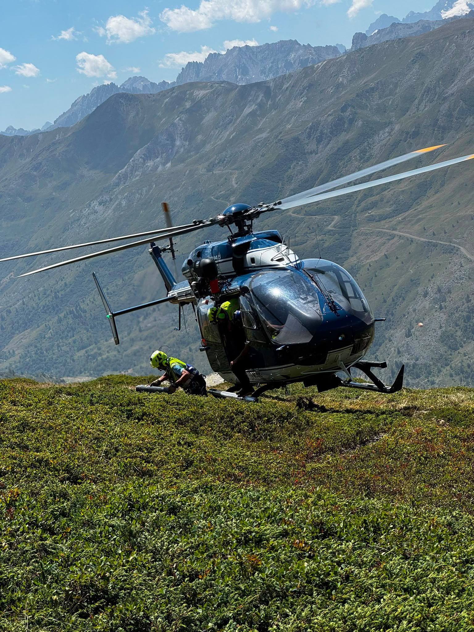 Hélicoptère et intervenants sur un versant de montagne lors d’une opération de secours